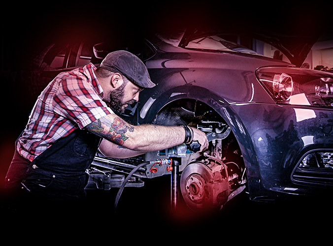 Mechaniker Martin Rasch mit VIGOR-Werkzeug am Auto